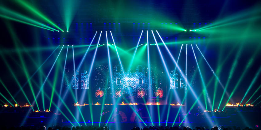 Trans-Siberian Orchestra performs classic Christmas ballads on stage under a mix of laser and strobe lights.