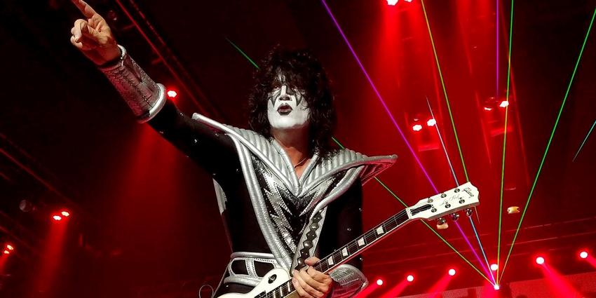KISS guitarist performs in red stage lighting and smoke, points to the crowd at the BJC in 2016