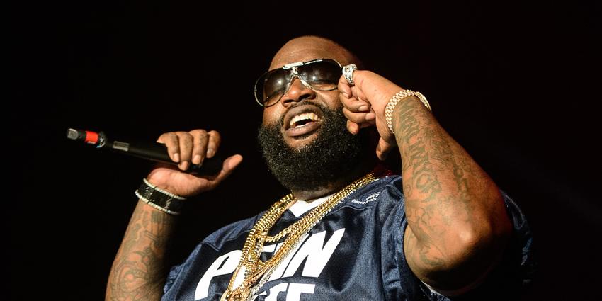 Rick Ross, wearing PSU football jersey and shades, raps for the audience at the Bryce Jordan Center in 2012.