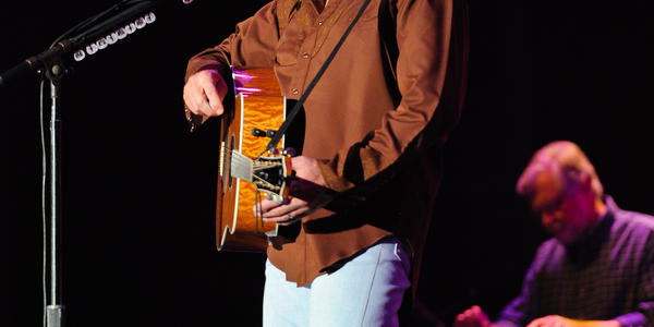 Alan Jackson plays guitar and sings on stage at the Bryce Jordan Center. 