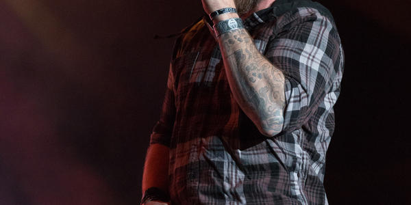 Brantley Gilbert sings into handheld microphone one stage during concert at BJC.