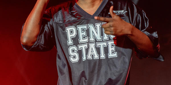 Kendrick Lamar wearing a PSU jersey, raps into handheld microphone during his performance at the BJC in 2013.