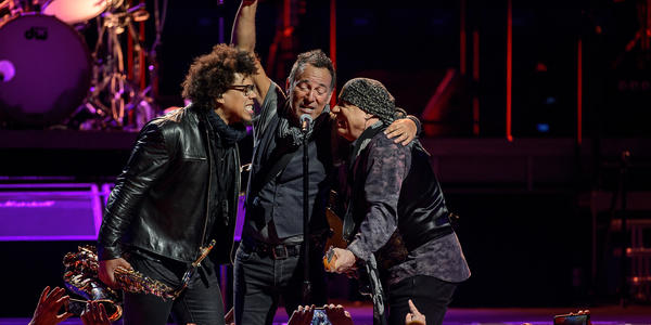 Bruce Springsteen & the E Street Band sing into a shared microphone during their concert at the BJC in 2016.