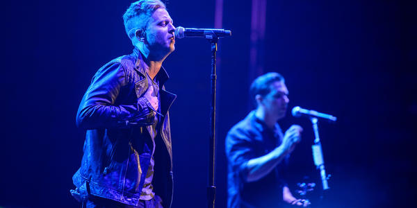 One Republic sings together on stage under blue lights during their concert at the Bryce Jordan Center in 2013.