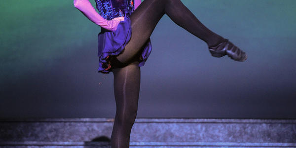 Lady dancer performs a high kick on point during the Riverdance's performance in 2012.