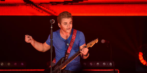 Hunter Hayes smiles at the crowd while playing his guitar. 