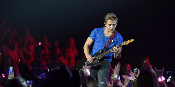 Hunter Hayes plays his guitar on stage for the crowd at the Bryce Jordan Center. 