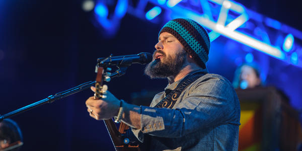 Lead singer, Zac Brown, sings into microphone while playing guitar during the Zac Brown Band performance at the BJC in 2012.