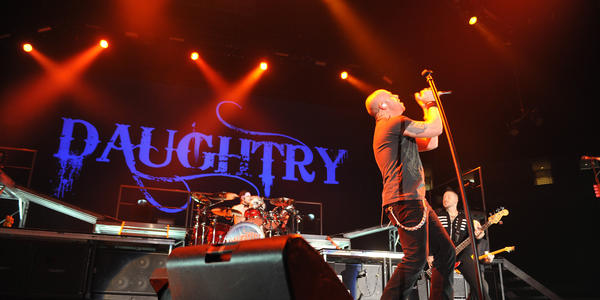 Daughtry performs on stage with red stage lighting for the audience at the BJC in 2010.