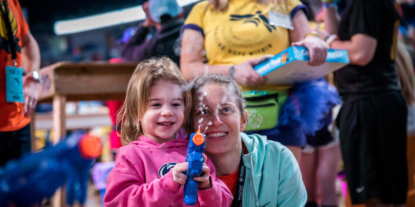THON child blowing bubbles with a THON member.